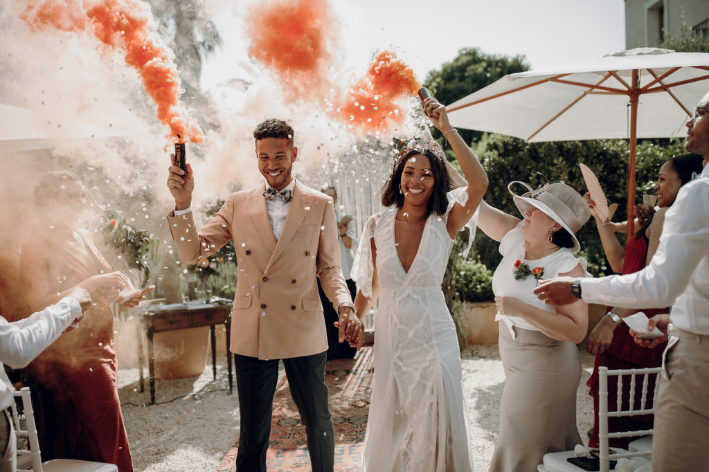 Wedding couple holding coloured flares
